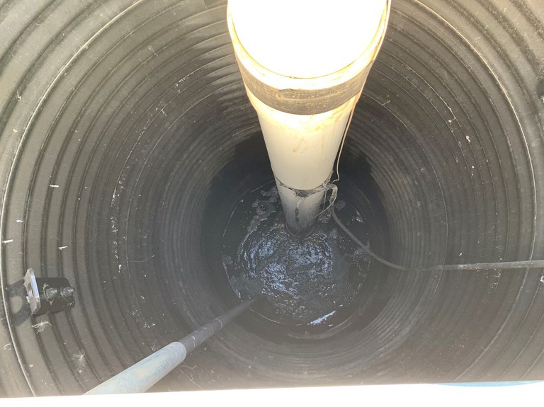 Figure 6. This submersible pump at the NDSU Langdon Research Extension Center tiled research site is not pumping water despite standing water at a low spot on Sept. 13, 2019, due to the poor soil water infiltration resulting in reduced drainage performance. The main drain is indicated by the arrow (see pdf version for red arrow). (N. Kalwar, NDSU)