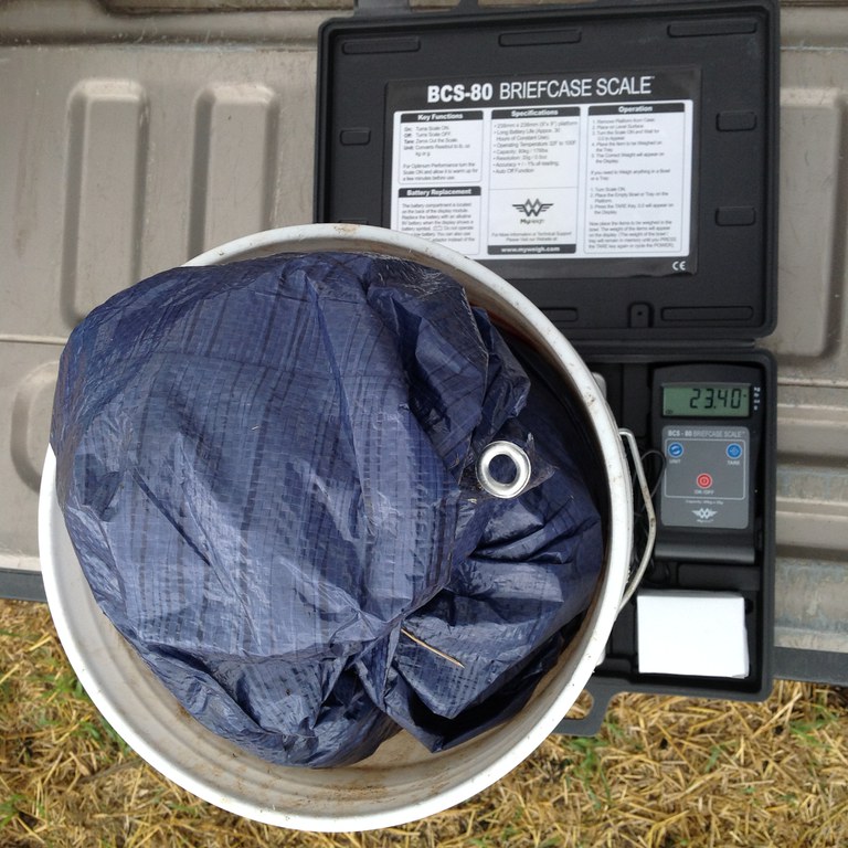 a plastic sheet containing manure on a scale