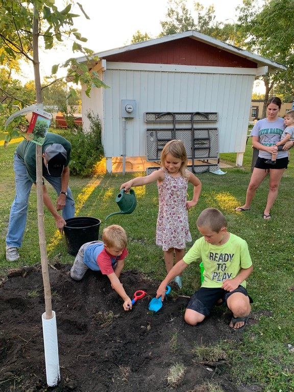 Young family planting a tree.