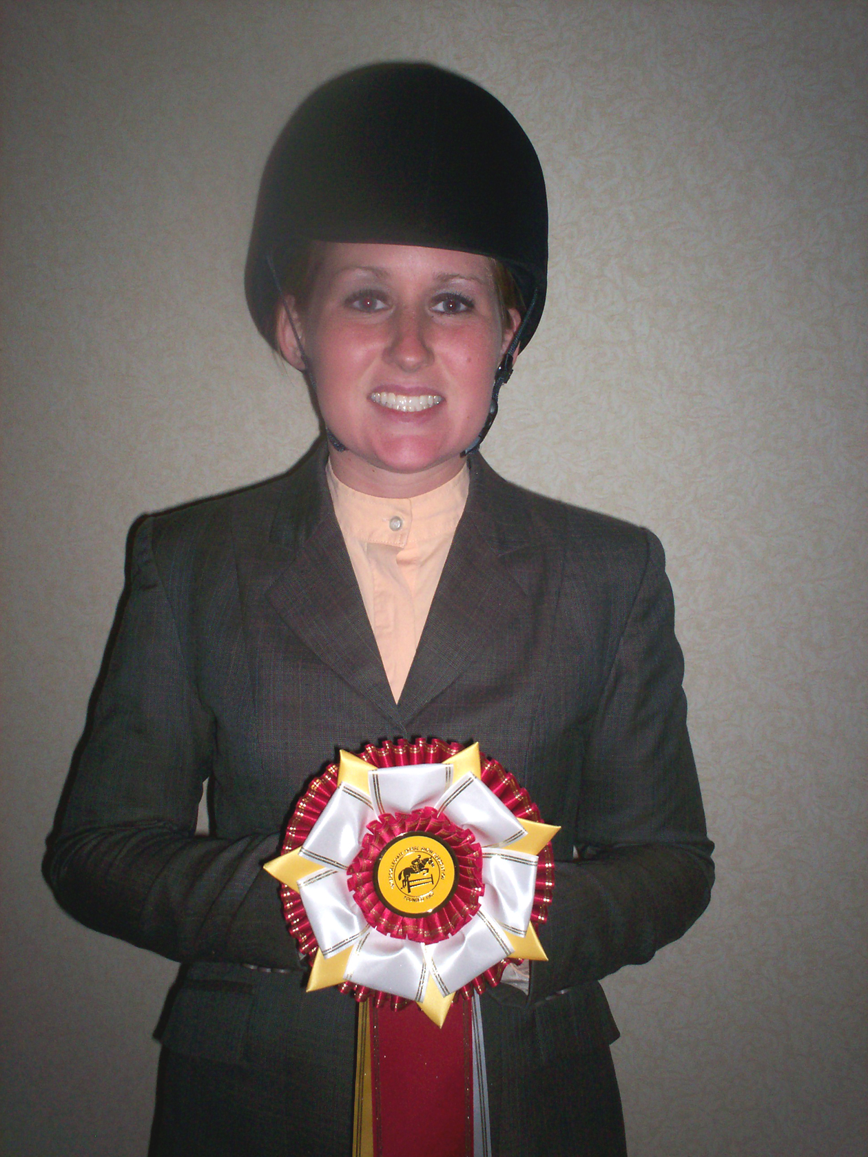 NDSU Intercollegiate Horse Show Association team member Katie Beaudine shows off the ribbon she received in a hunt seat competition.