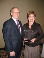 D.C. Coston, NDSU vice president for Agriculture and University Extension, presdents Carol Goodman with the Joseph A. Chapman Leadership Award.