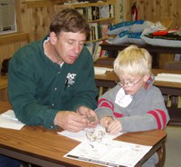 A youngster is getting a little help from Benson County Extension agent Scott Knoke in dissecting an owl pellet during a 4-H project day event.