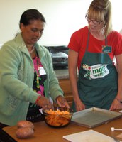 Grand Forks County Extension agent Donna Bernhardt, right, helps a woman make baked sweet potato fries during a cooking class for new Americans.