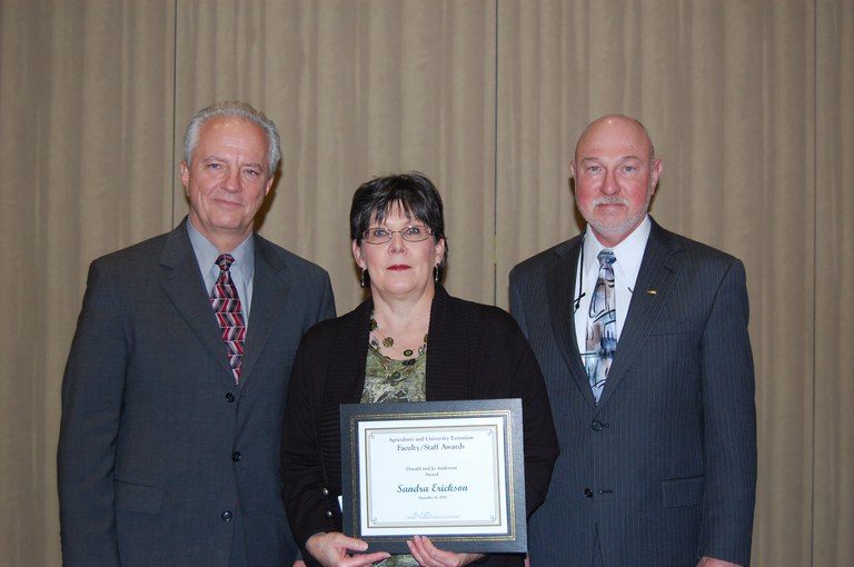 Sandy Erickson receives the Donald and Jo Anderson Staff Award from Duane Hauck (left), Extension Service director, and Ken Grafton, vice president for Agriculture and University Extension.