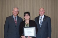 Sandy Erickson receives the Donald and Jo Anderson Staff Award from Duane Hauck (left), Extension Service director, and Ken Grafton, vice president for Agriculture and University Extension.