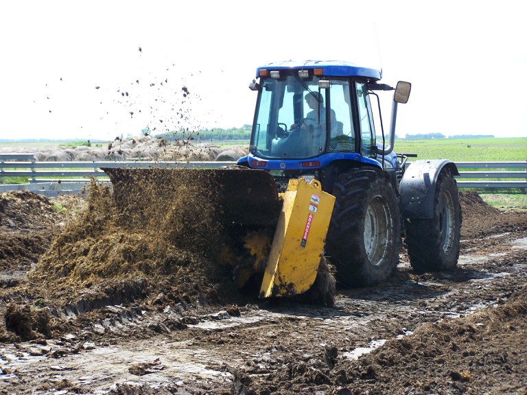 Anne Ehni, Wells County Soil Conservation District manager, demonstrates how to use a front-mounted composting windrow turner.