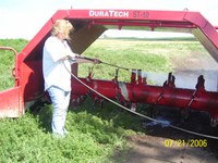 Anne Ehni, Wells County Soil Conservation District manager, demonstrates how to power wash a compost turner. (Photo courtesy of Anne Ehni)