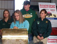 Stutsman County 4-H'er Sara Hatlewick draws the winner of the Growing Great Leaders raffle while 4-H Ambassadors (from left to right) Elizabeth Gunderson, Brett Levos and Chelsy Nelson watch. Hatlewick was the youth who sold the most raffle tickets.