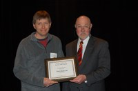 Kirk Anderson (left) receives the Charles and Linda Moses Staff Award from Ken Grafton