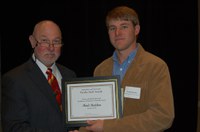 Reid Redden (right) receives the Myron and Muriel Johnsrud Excellence in Extension/Outreach Award from Ken Grafton