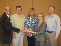 Jimmy Henning, Kentucky Cooperative Extension Service director (left), presents a Be, Grow, Create Outstanding Institutional Team Award to members of NDSU's eXtension institutional team. Team members receiving the award are (from left) Bob Bertsch, Ag Communication Web technology specialist; Debra Pankow, Human Development and Family Science assistant professor/Extension family economics specialist; Becky Koch, Ag Communication director; and Greg McKee, Agribusiness and Applied Economics associate professor and Quentin Burdick Center for Cooperatives director.