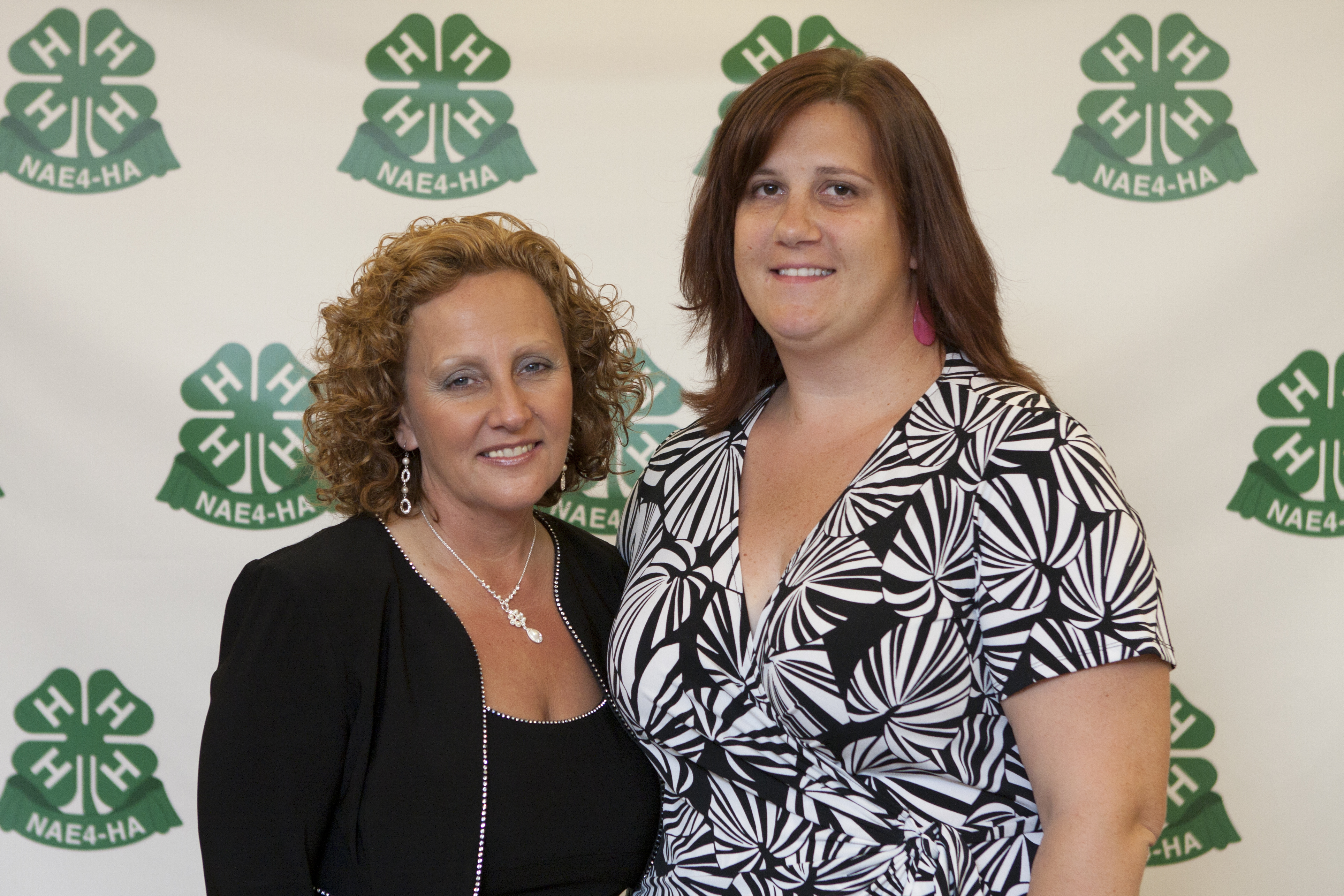 National Association of Extension 4-H Agents President Debbie Nistler, left, congratulates Samantha Roth, recipient of the Achievement in Service Award.