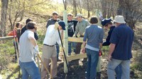 Members of Boy Scout Troop 214 and adult volunteers are building a fence stile on the new hiking trail near Kindred. (Photo by Jim Laschkewitsch, a Troop 214 member)