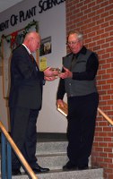 Ken Grafton (left), vice president for Agricultural Affairs; dean of the College of Agriculture, Food Systems, and Natural Resources; and director of the North Dakota Agricultural Experiment Station, presents a clock to Lund during the dedication. (Photo by Alisha Nord)
