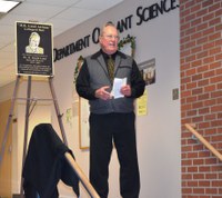Lund standing next to the plague that will be placed in Loftsgard Hall naming the atrium in his honor. (Photo by Alisha Nord)