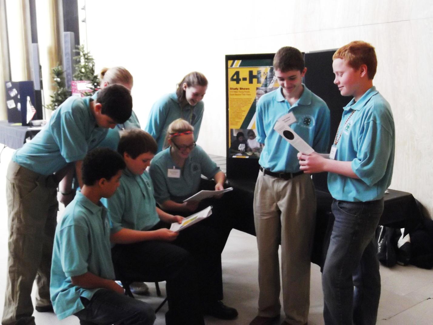 4-H members (seated from left to right) Niklas Marks of Stutsman County, Nolan Hintz of Morton County and Sara Hatlewick of Stutsman County, (standing behind them from left to right) Layne Entzi of Stutsman County, Mikaela Cofield of Stutsman County and Rebecca Johnson of Benson County face Isaac Huber of Stutsman County (left) and William Liffrig of Oliver County as they prepare to speak with legislators at the 2013 Citizenship in Action event in Bismarck.