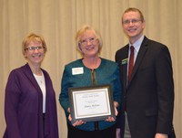 Linda McCaw, administrative assistant/conference coordinator/Ag Consortium scheduler, Agriculture Communication (center), receives the Donald and Jo Anderson Staff Award from Chris Boerboom, director of the NDSU Extension Service, and Becky Koch, director of Agriculture Communication.