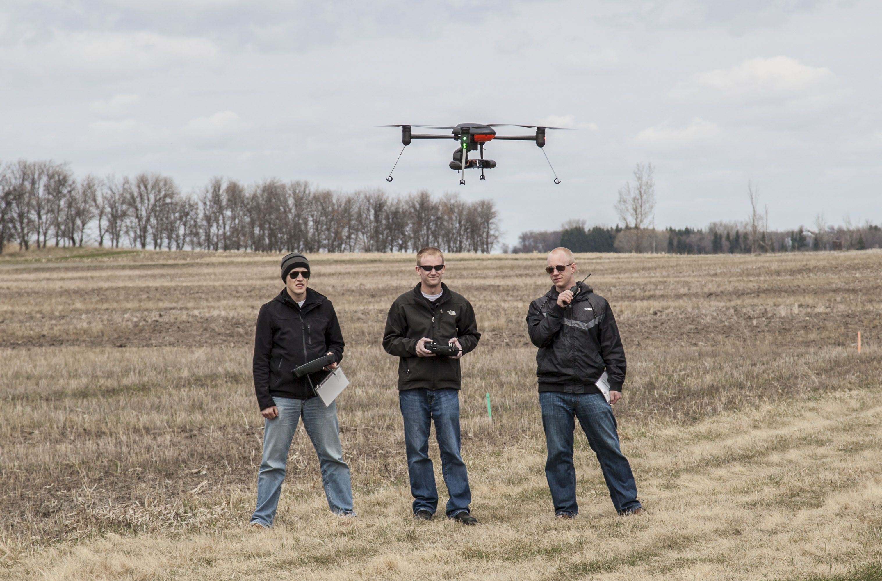 Jakee Stoltz (left), Trevor Woods (center) and Logan Lass of UND's Center for Unmanned Aircraft Systems Research, Education and Training are conducting a test flight of an unmanned aircraft system as part of a research project at NDSU's Carrington Research Extension Center. (NDSU photo)