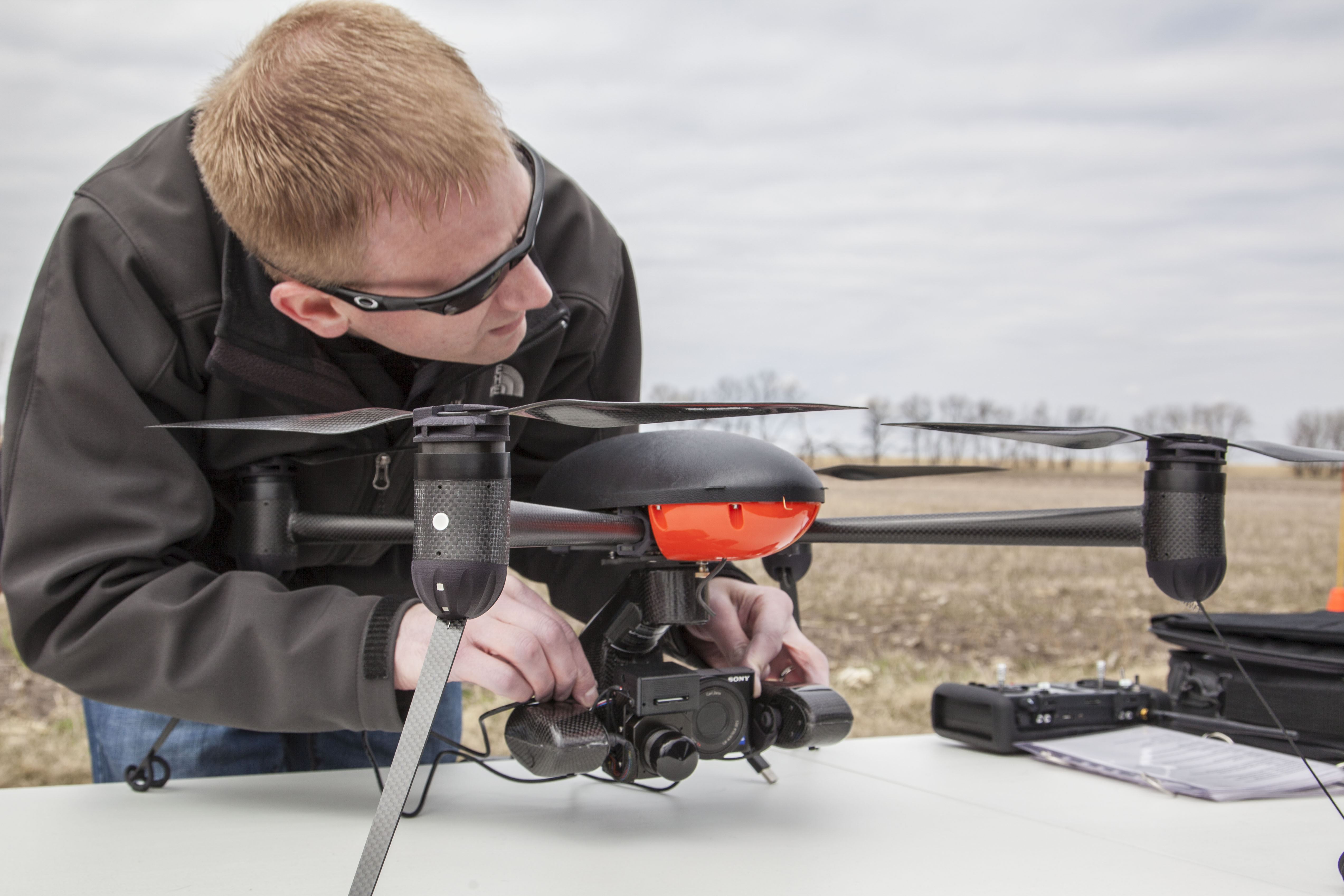 Trevor Woods of the UND Center for Unmanned Aircraft Systems Research, Education and Training is checking the camera on an unmanned aircraft system that's being used in a research project at NDSU's Carrington Research Extension Center. (NDSU photo)