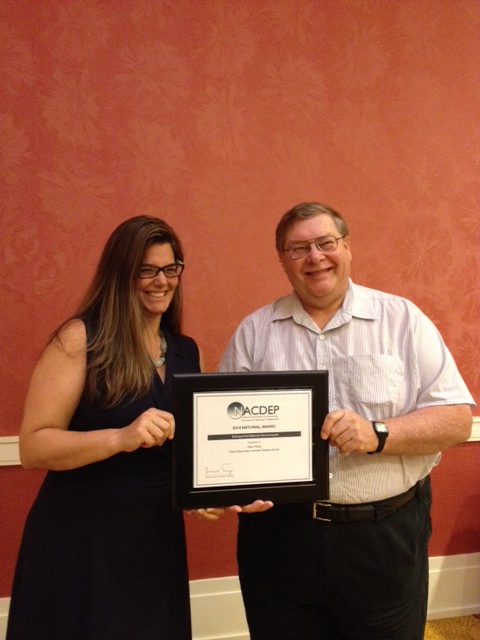 Glenn Muske, NDSU Extension rural and agribusiness enterprise development specialist, receives the Distinguished Service Award from National Association of Community Development Extension Professionals' President Alison Davis.