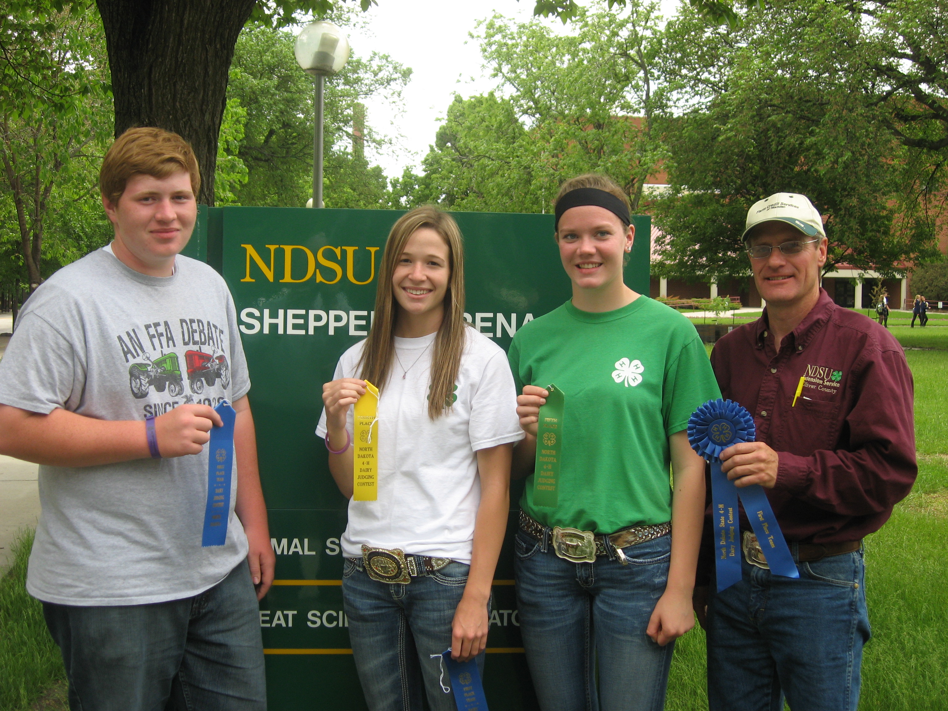 Oliver County team members (from left) Shane Giedd, Rachel Oliver and Emily Klein, and their coach, Extension agent Rick Schmidt, display ribbons the team received in the senior division of the 4-H dairy judging contest at NDSU.
