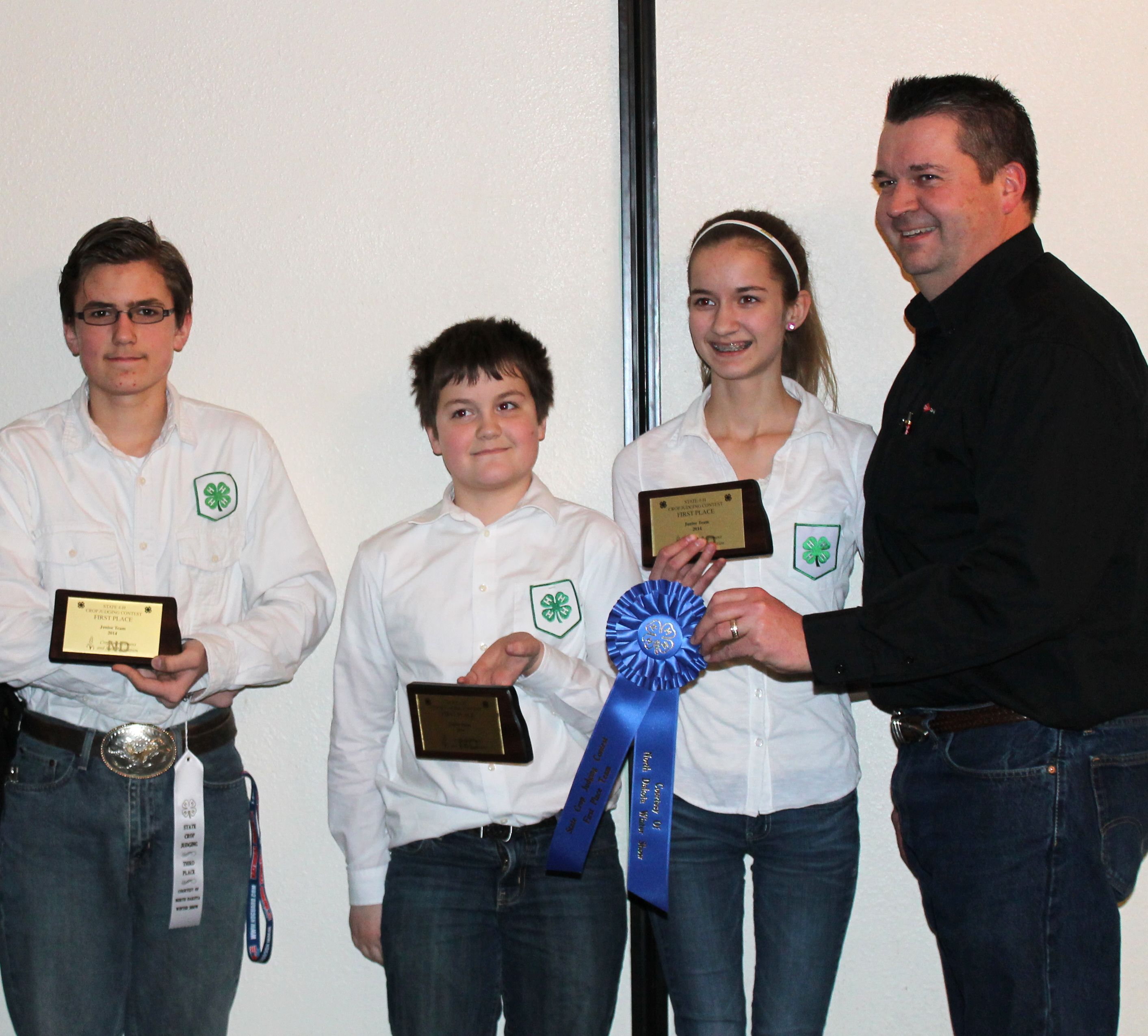 The combined LaMoure/Grand Forks County team took first place in the junior division of the crop judging contest at the North Dakota Winter Show. Team members are (from left) Thomas Granger of Grand Forks County, and Zach Lahlum and Eva Lahlum of LaMoure County. They are accompanied by their coach, Eric Lahlum (far right).