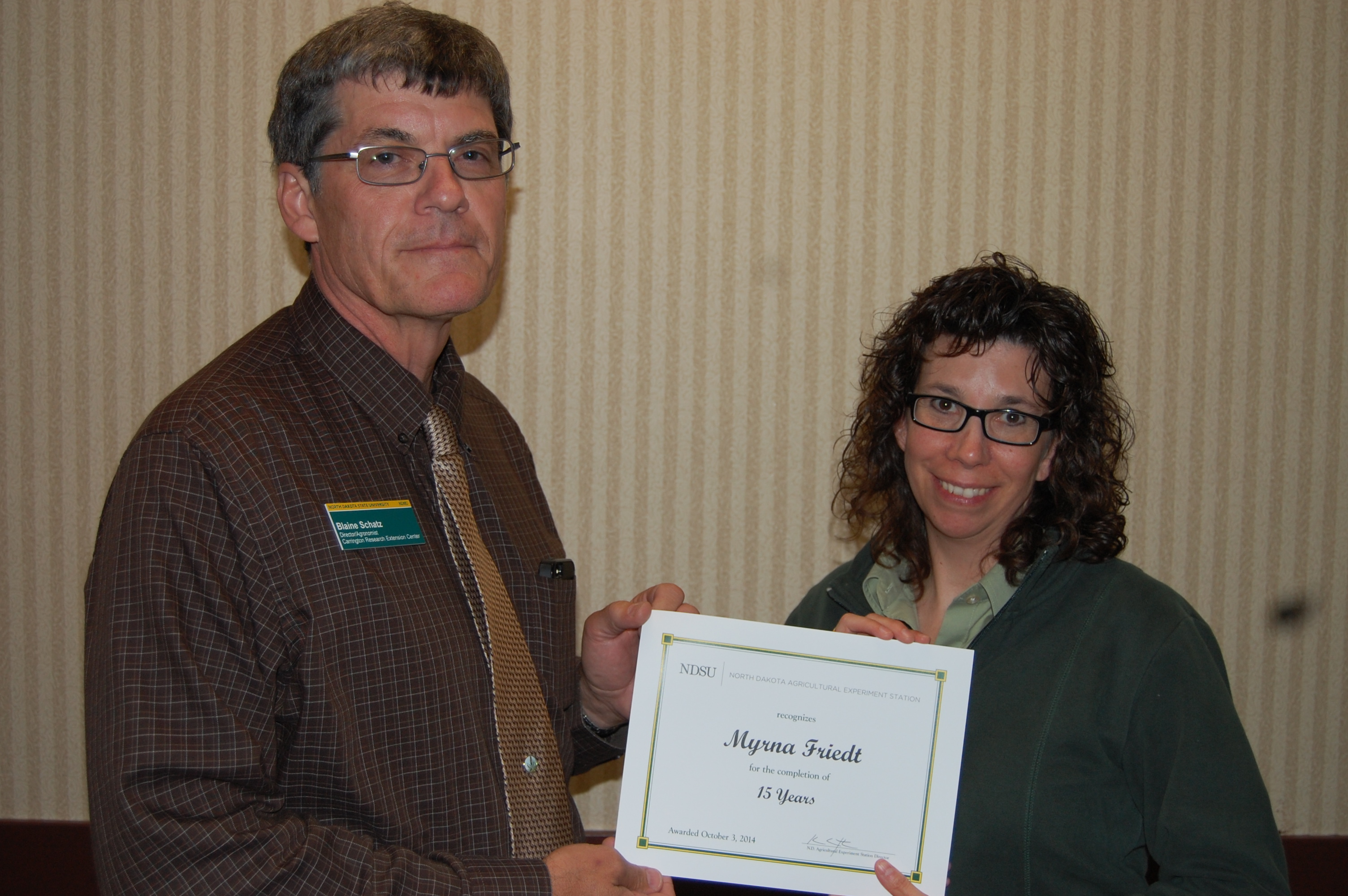 Blaine Schatz, Carrington Research Extension Center director, presents the award to Myrna Friedt.