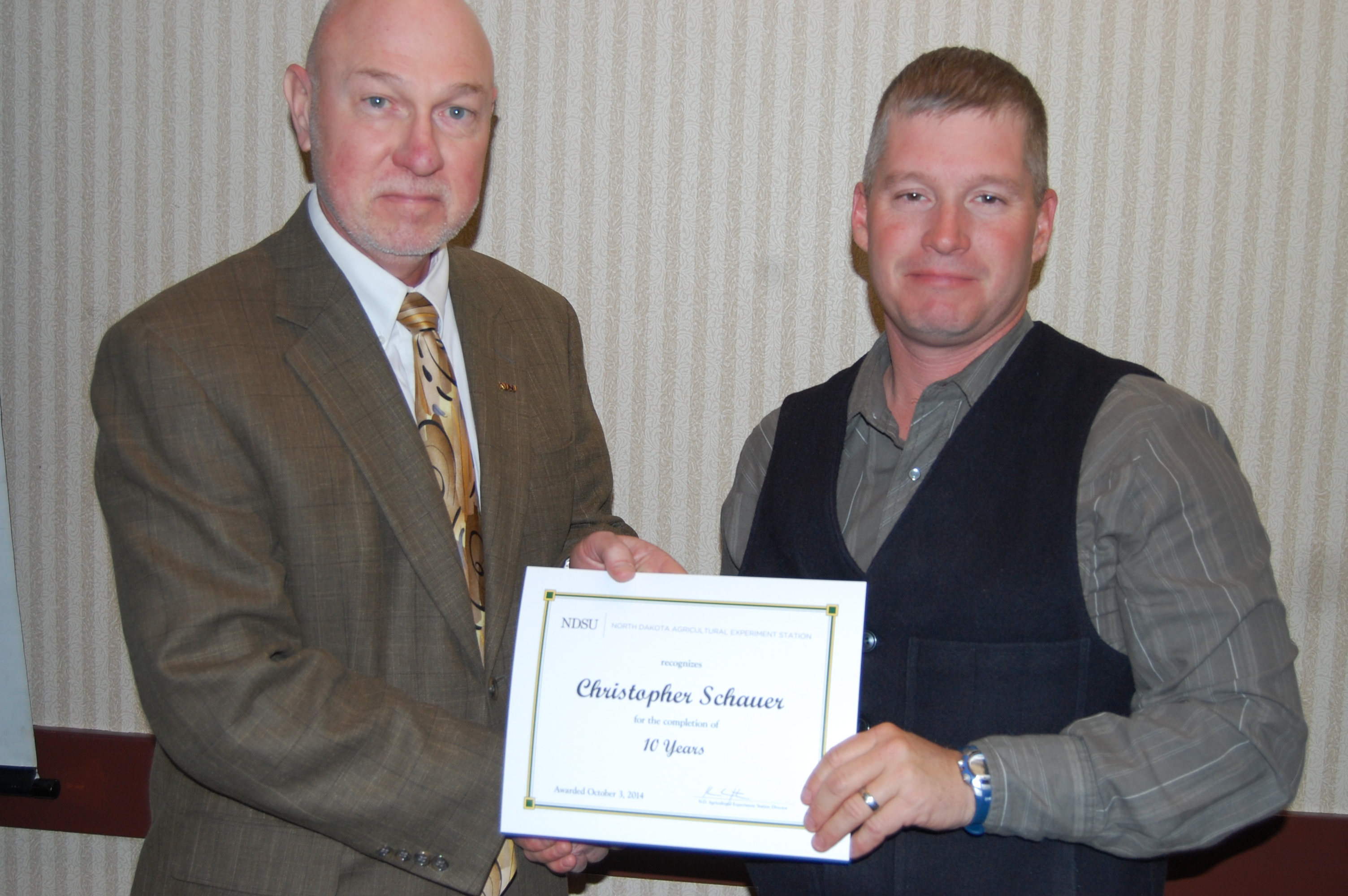 Ken Grafton, vice president for Agricultural Affairs, director of the North Dakota Agricultural Experiment Station and dean of the College of Agriculture, Food Systems, and Natural Resources (left), presents the award to Christopher Schauer.