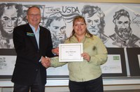 Randy Mehlhoff, Langdon Research Extension Center dirctor, presents the award to Lisa Pederson.