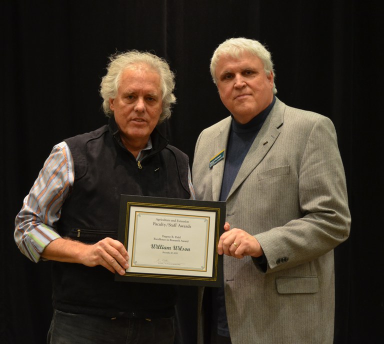 David Buchanan, associate dean for academic programs in the College of Agriculture, Food Systems, and Natural Resources (right), presents the  Eugene R. Dahl Excellence in Research Award to William Wilson, professor, Department of Agribusiness and Applied Economics. (NDSU photo)