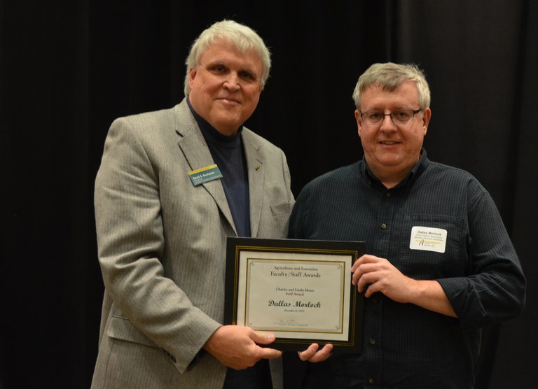 David Buchanan, associate dean for academic programs in the College of Agriculture, Food Systems, and Natural Resources (left), presents the Charles and Linda Moses Staff Award to Dallas Morlock, computer programmer, North Dakota Agricultural Weather Network. (NDSU photo)