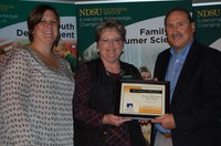 Wally Erhardt receives the Friend of the North Dakota Extension Association of Family and Consumer Sciences Award on behalf of the Bank of North Dakota's Student Loan Division. Association president Samantha Roth (left), an Extension agent for Stark and Billings counties, and Vanessa Hoines (center), an Extension agent in Morton County, presented the award. (NDSU photo)