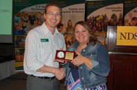 Association for Communication Excellence state representative Scott Swanson congratulates Mary Berg, the 2015 Communicator of Achievement. (NDSU photo)