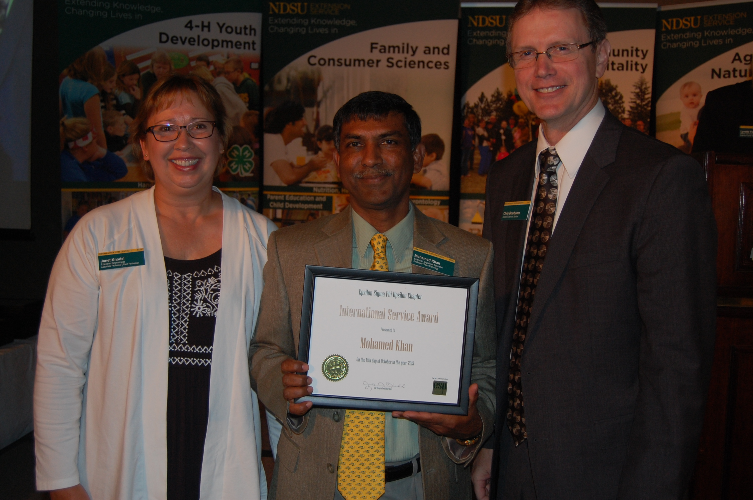 Janet Knodel (left) and Chris Boerboom present Mohamed Khan the award.