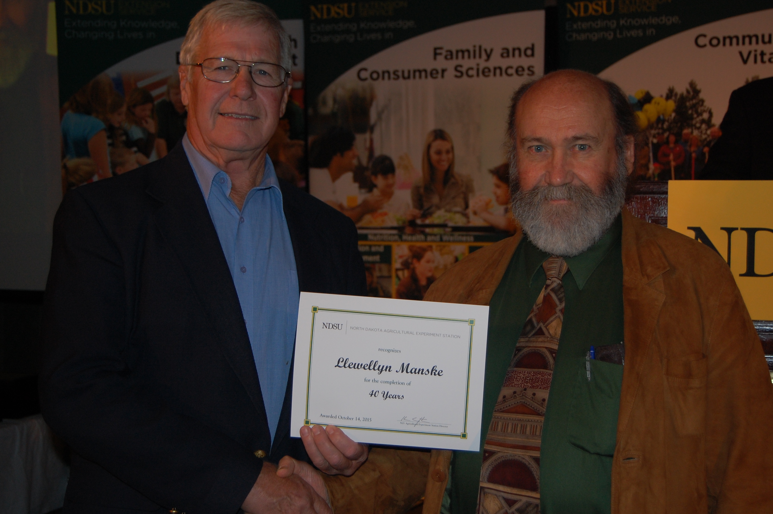 Llewellyn Manske (left; award presented by Tim Faller, N.D. Agricultural Experiment Station assistant director, right)