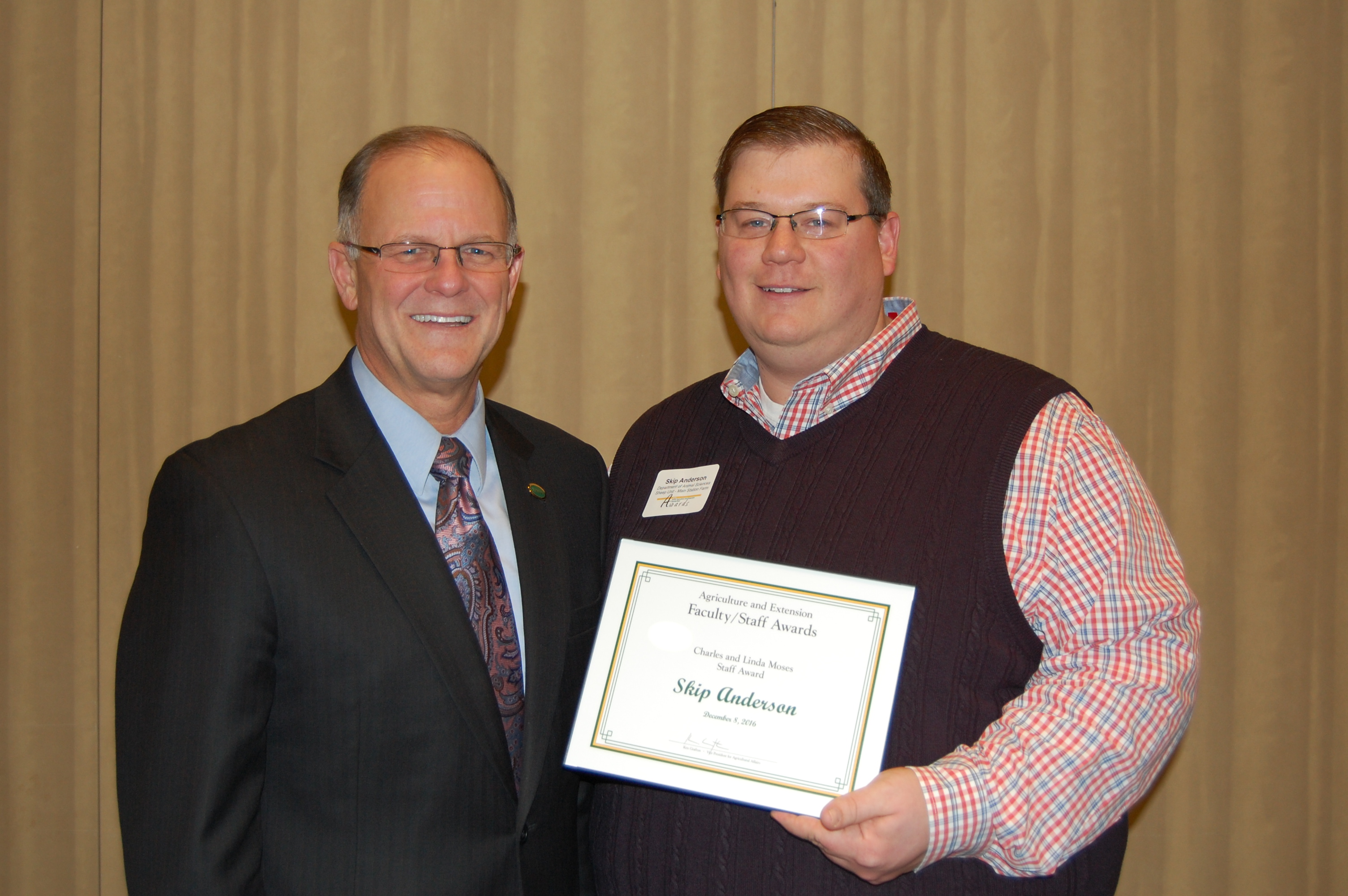 NDSU Sheep Unit manager Skip Anderson, right, receives the Charles and Linda Moses Staff Award during the 25th annual Agriculture and Extension Faculty/Staff Awards program Dec. 8. Also pictured is NDSU President Dean Bresciani. (NDSU photo)
