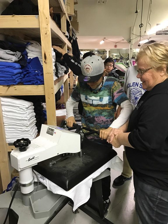 Sue Isbell (right), the NDSU Extension Service's 4-H youth development agent in Sioux County, works with a youth at Sioux Image. It's an embroidery, printing and silkscreening business Isbell partnered with Solen High School to develop to give youth in grades seven to 12 hands-on experience in operating a business. (NDSU photo)