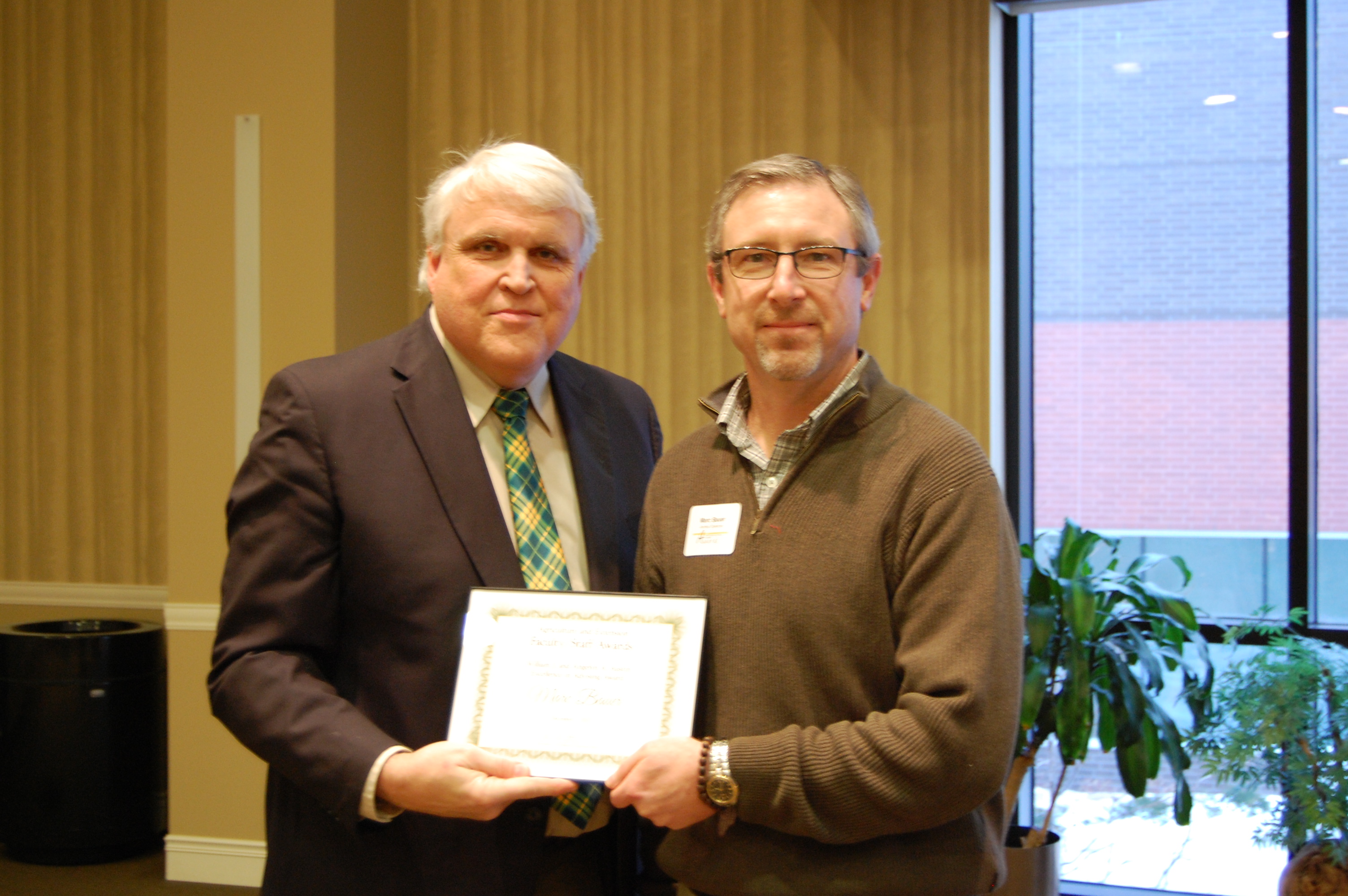 Marc Bauer, right, receives the William J. and Angelyn A. Austin Excellence in Advising Award from David Buchanan, associate dean for academic programs. (NDSU photo)