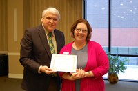 Shannon Ueker receives the Donald and Jo Anderson Staff Award from David Buchanan, associate dean for academic programs. (NDSU photo)