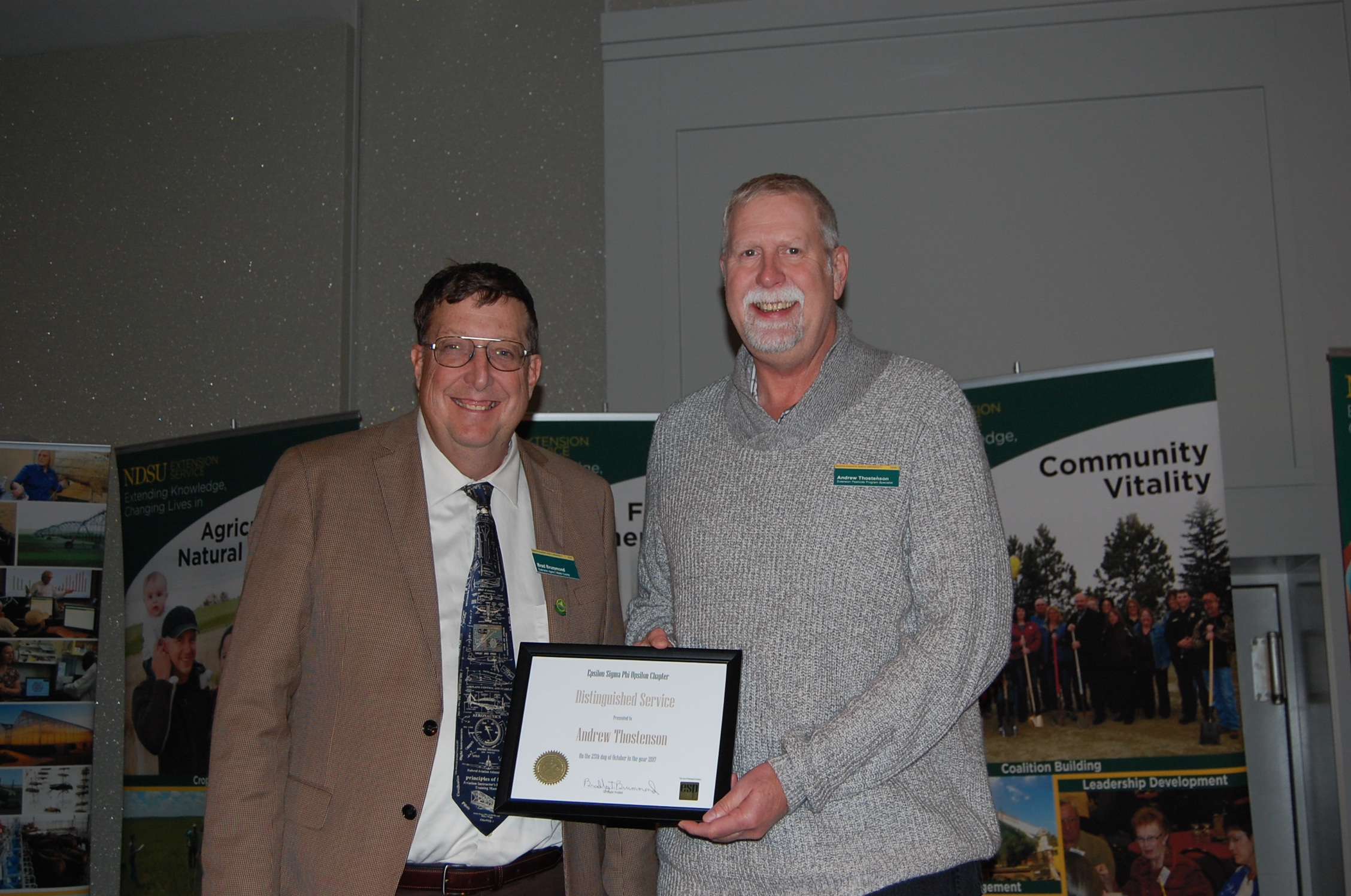 Andrew Thostenson (right) receives the Distinguished Service Award from Brad Brummond, an agent in NDSU Extension's Walsh County office and president of the Upsilon Chapter of Epsilon Sigma Phi. (NDSU photo)