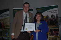 Esther McGinnis receives the Early Career Service Award from Brad Brummond, an agent in NDSU Extension's Walsh County office and president of the Upsilon Chapter of Epsilon Sigma Phi. (NDSU photo)