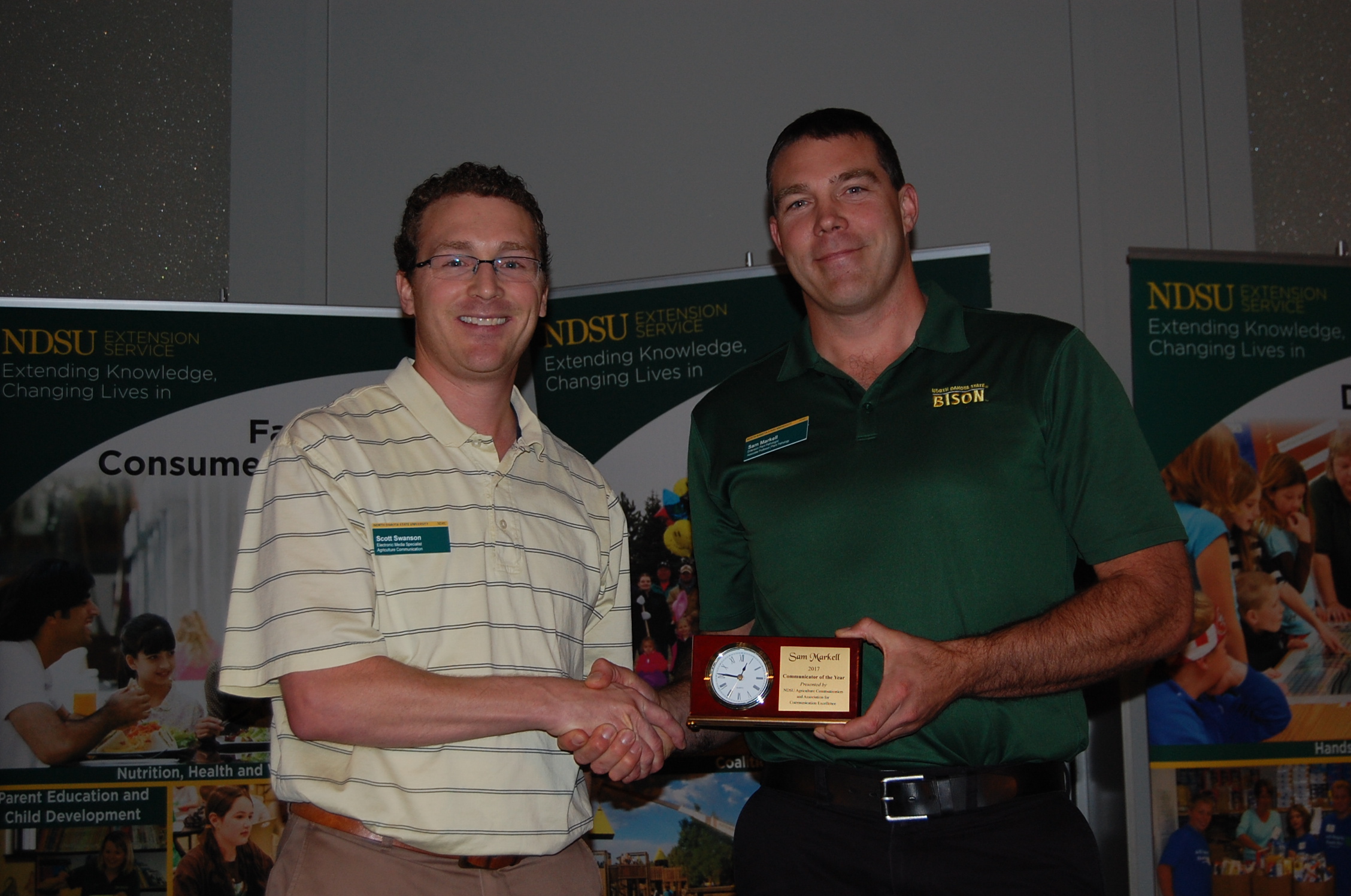 Sam Markell (right) receives the Communicator of the Year Award from Scott Swanson, NDSU Agriculture Communication electronic media specialist and representative of the Association for Communication Excellence's North Dakota chapter. (NDSU photo)
