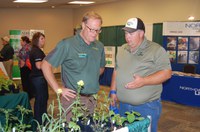 Tom Peters, NDSU Extension sugar beet agronomist (center), talks to a visitor about weeds during a Big Iron Farm Show. (NDSU photo)