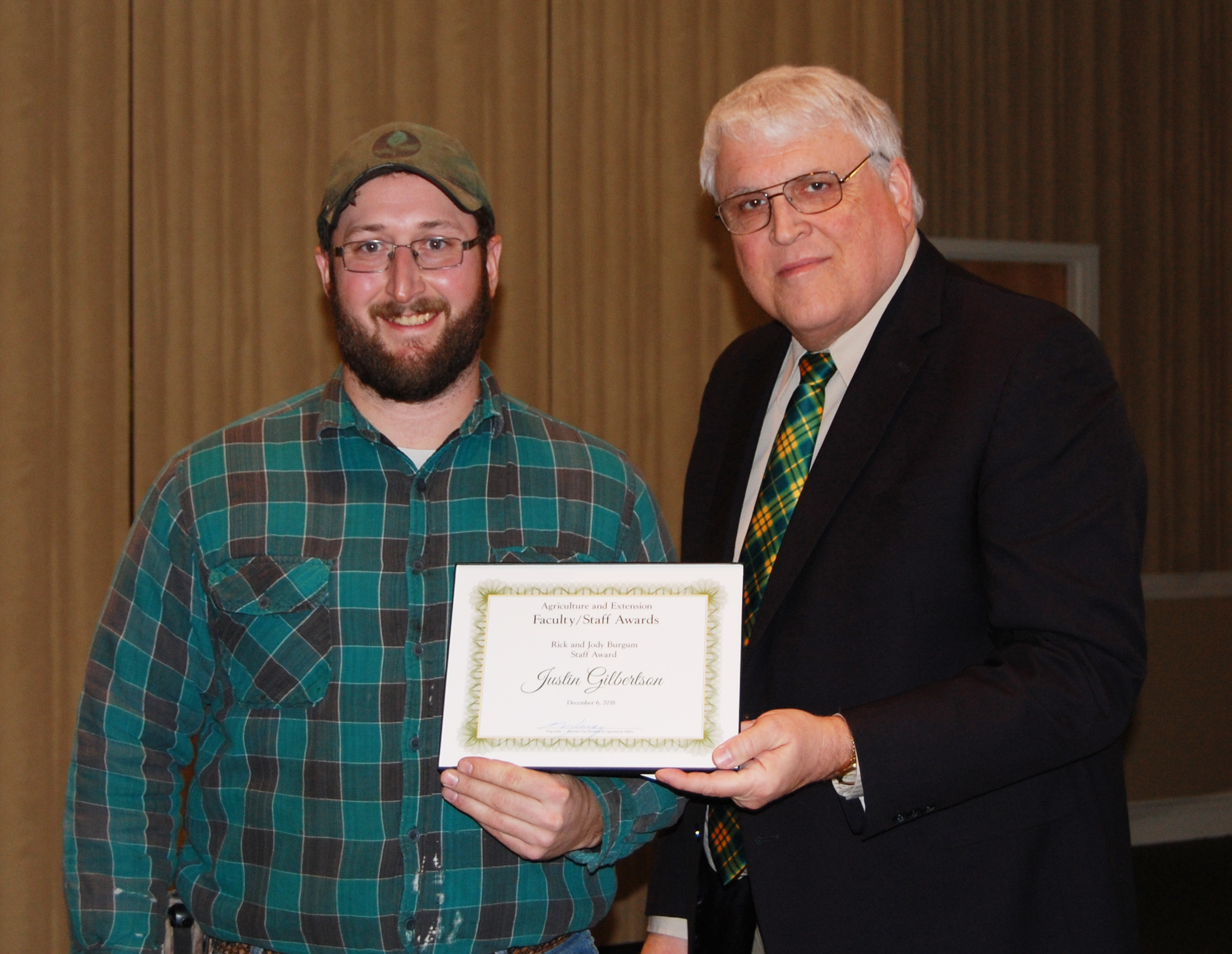 Justin Gilbertson, left, receives the Rick and Jody Burgum Staff Award from David Buchanan, associate dean for academic programs. (NDSU photo)