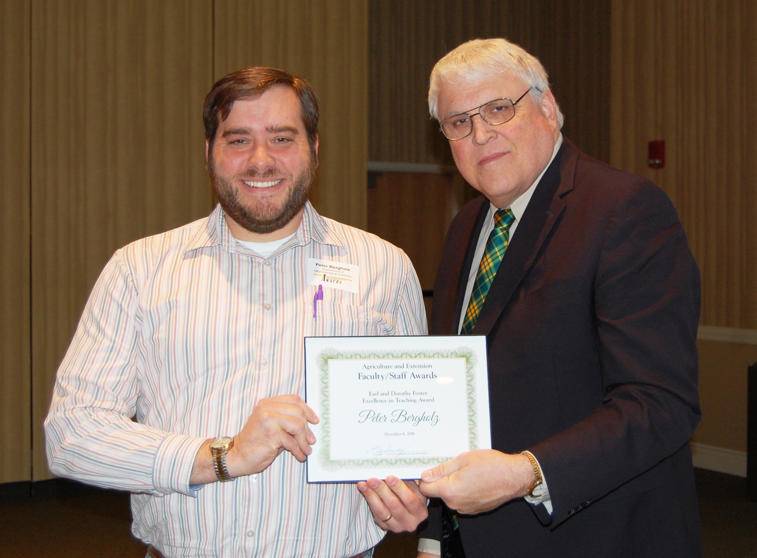 Peter Bergholz, left, receives the Earl and Dorothy Foster Excellence in Teaching Award from David Buchanan, associate dean for academic programs. (NDSU photo)