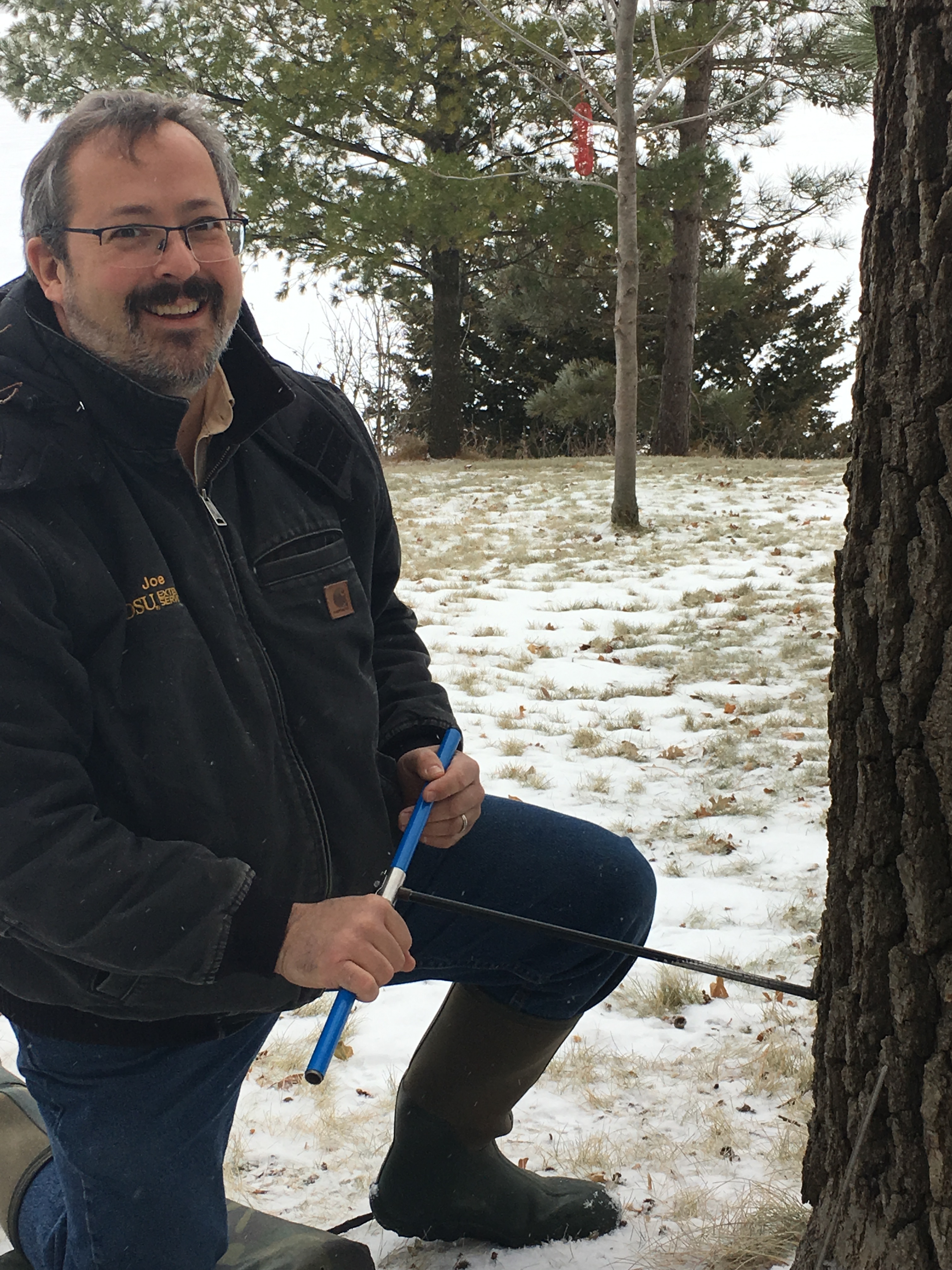 NDSU Extension forester Joe Zeleznik collects a sample from a bur oak along the Red River. (NDSU photo)