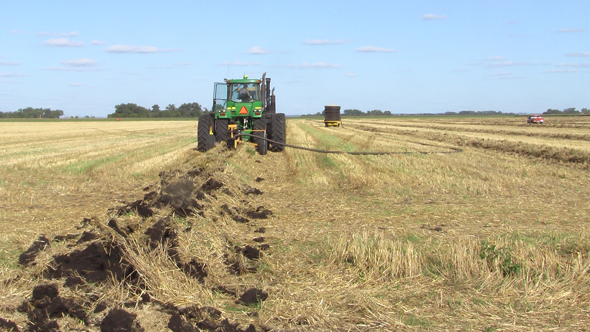 Workers install drain tile in a field. (NDSU photo)