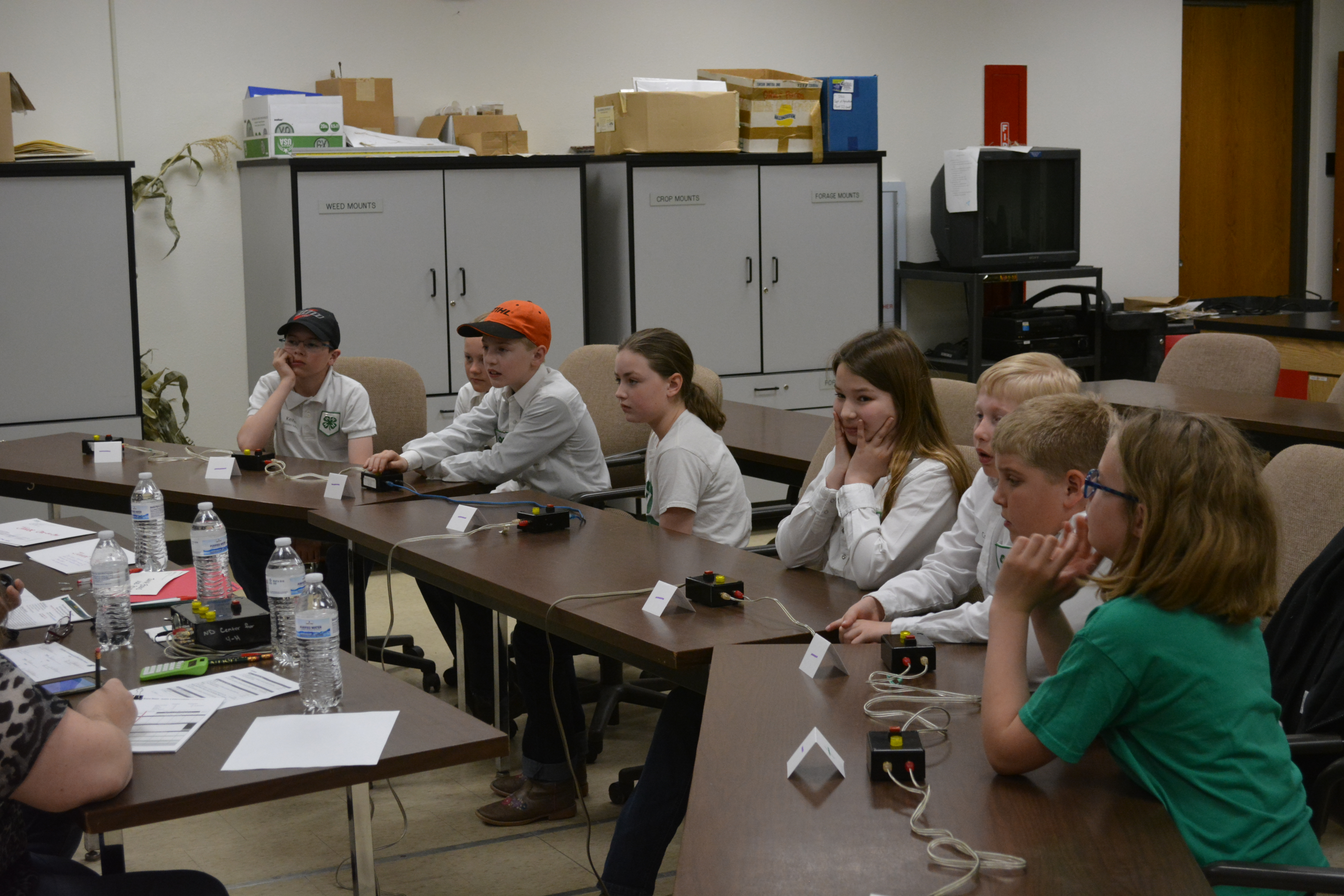 Two junior teams get ready for their first round in the inaugural State 4-H Livestock Quiz Bowl. Pictured are (from left): Golden Valley County team members Kieffer Ernst, Harley Feiring, Lucas Brown and Leah Davidson, and Stark/Billings County team members Shaylynn Berthold, Coy Melchior, Trevor Lefor and Hadley Talkington. (NDSU photo)