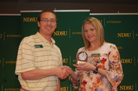 Miranda Meehan, NDSU Extension livestock environmental stewardship specialist, receives the 2018 Communicator of the Year award from Scott Swanson, NDSU Agriculture Communication electronic media specialist and state representative for North Dakota's chapter of the Association for Communication Excellence. (NDSU photo)
