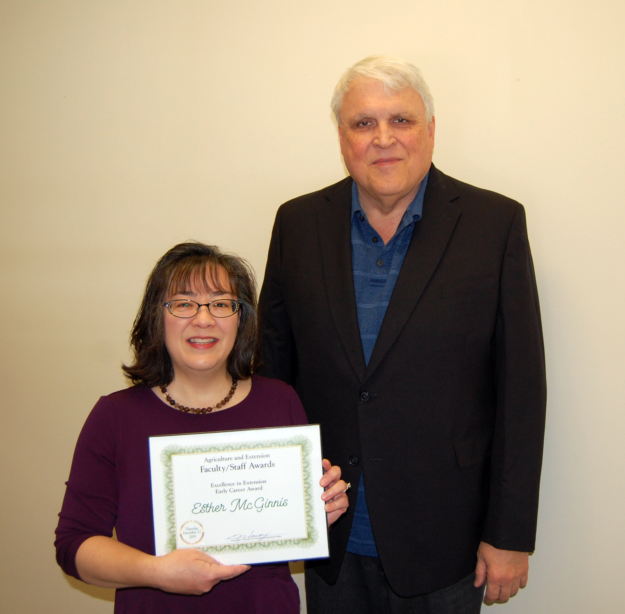 Esther McGinnis, left, receives the Excellence in Extension Early Career Award from David Buchanan, associate dean for academic programs. (NDSU photo)